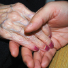 Alte und junge Hand halten einander